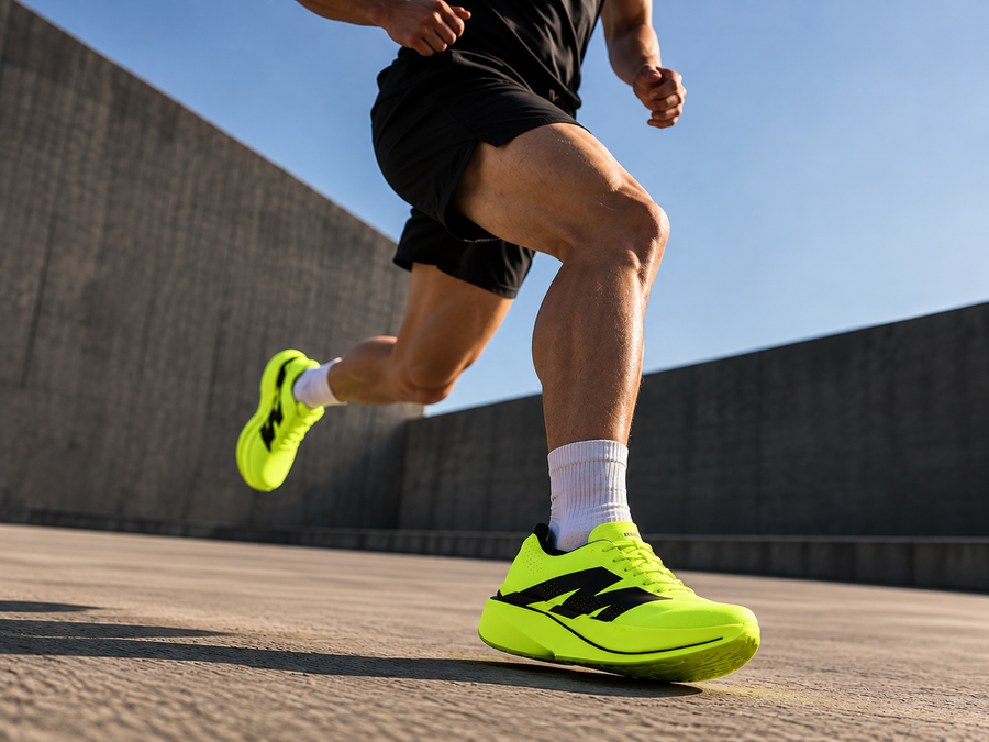 Runner in black shorts and AURORO MOVE shoes mid-stride on a concrete rooftop under a blue sky