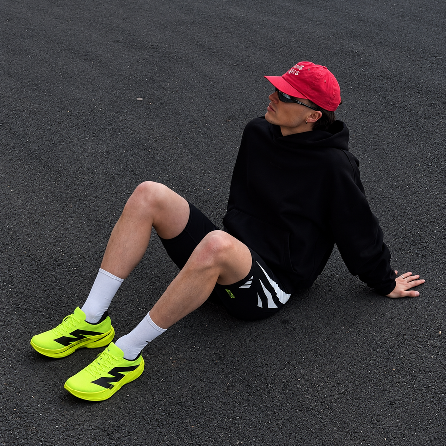Man sitting on asphalt in AURORO MOVE running shoes