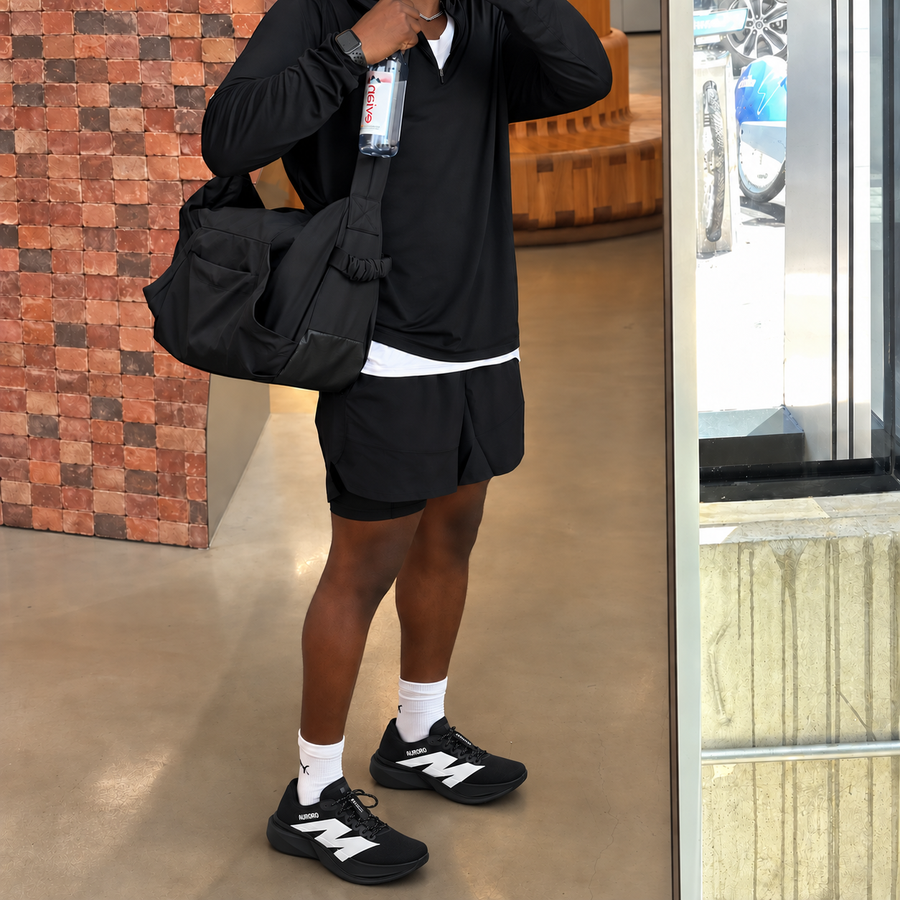 Man walking with a duffel bag in AURORO MOVE shoes