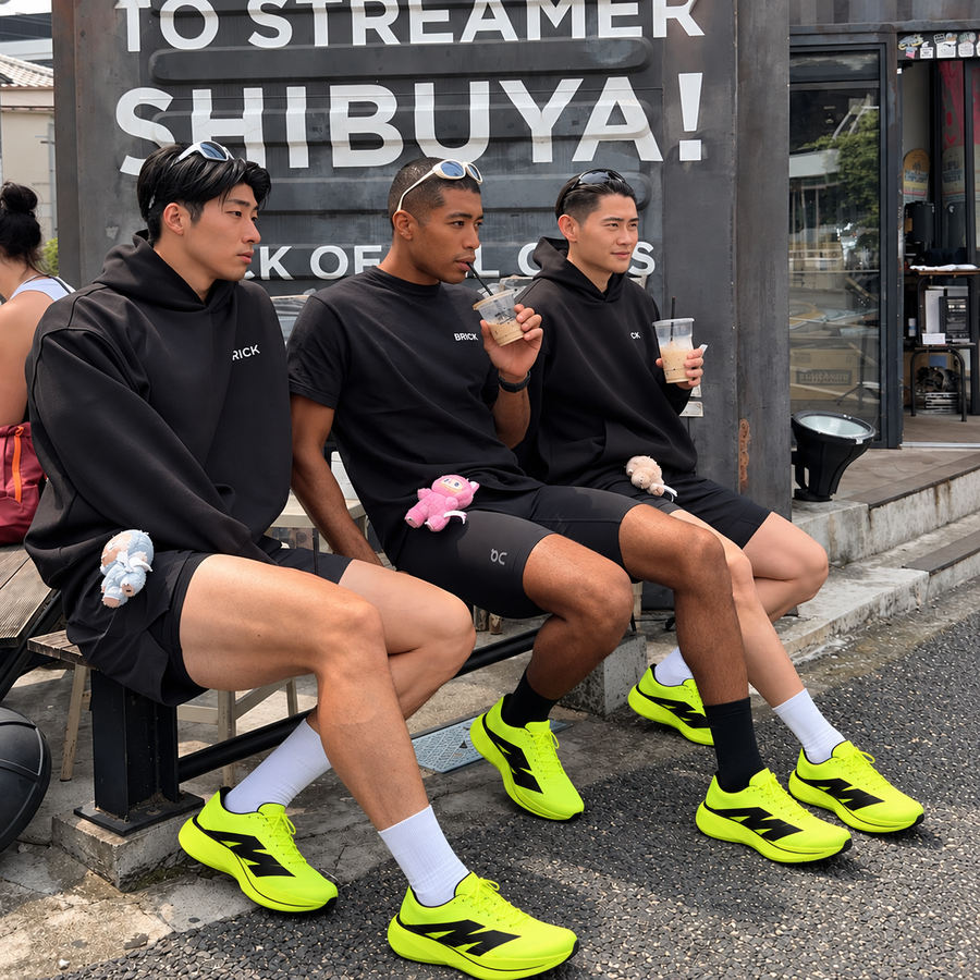 Three men sitting on a bench in AURORO MOVE shoes